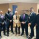 Governor Wilder receives his 75th service medallion and certificate from Omega Psi Phi. Fraternity, Inc. Standing are six men with Governor Wilder in the middle